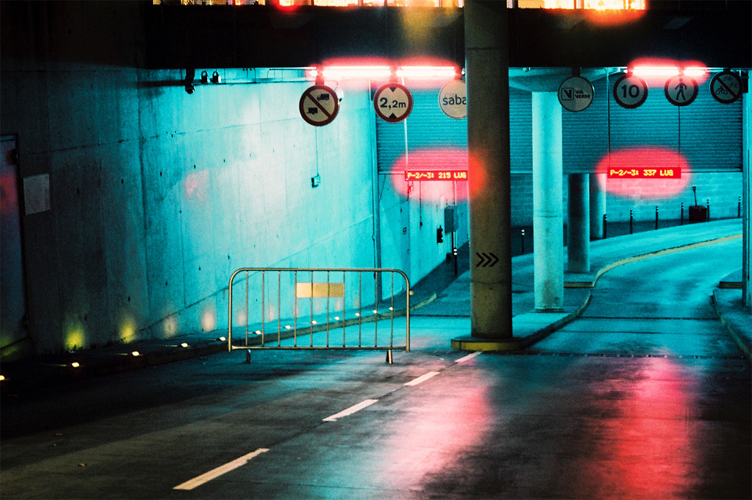 Analog photo of a parking garage entrance at night.