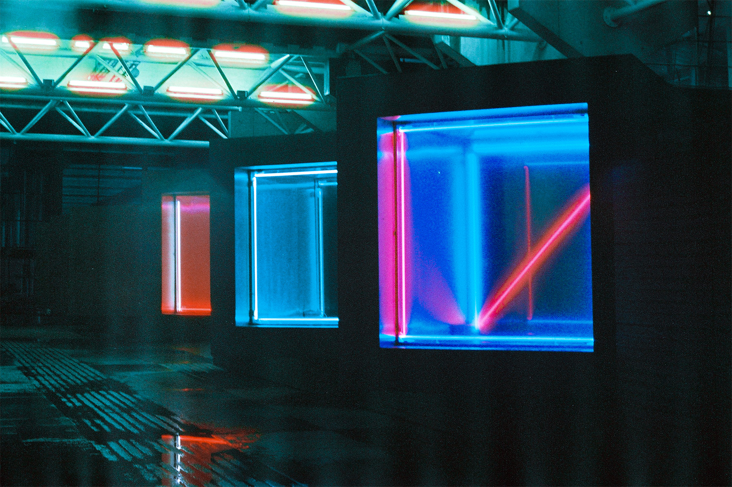 Analog photo of an art installation with neon lights at night.