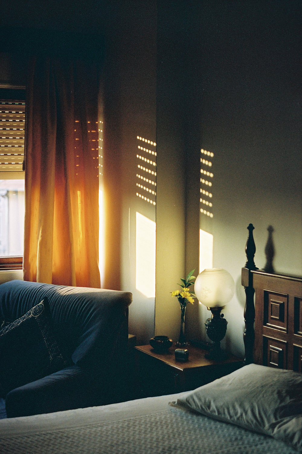 Analog photo of a bedroom, light shining through a window on the left.