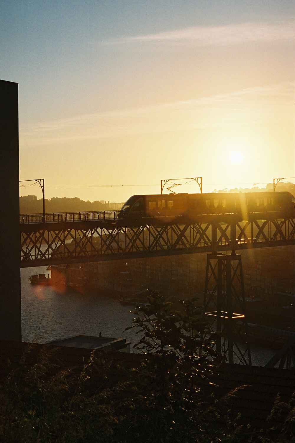 Analog photo of the subway crossing a bridge in Porto while the sun is going down.