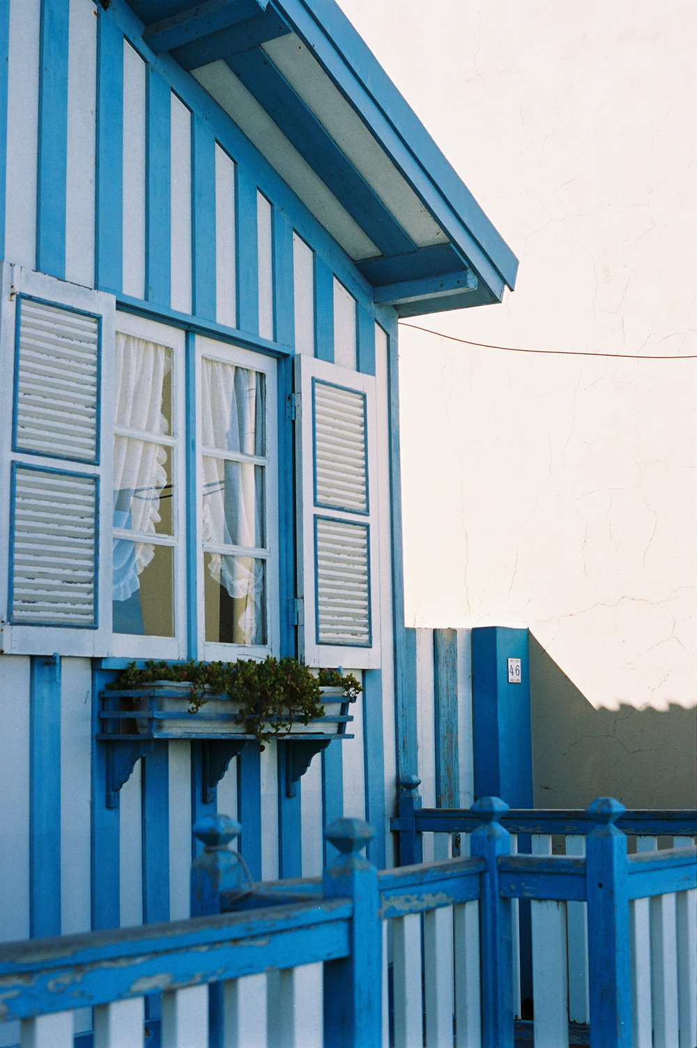 Analog photo of a striped blue and white beach house.