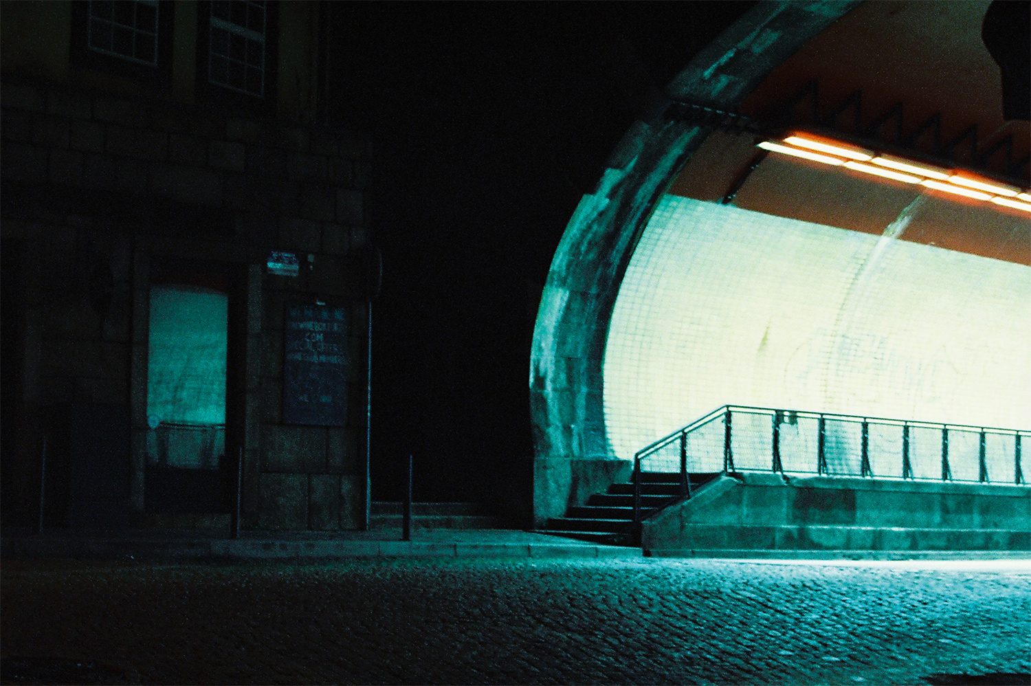 Analog photo of the entrance of a tunnel at night.