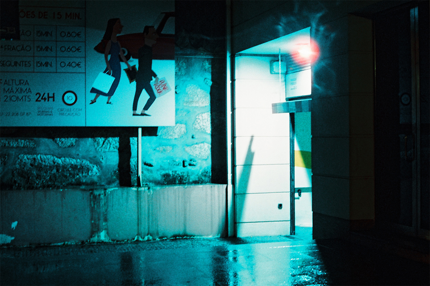 Analog photo of a parking garage entrance at night.